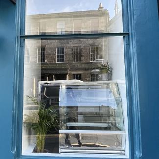 Empty window of former Broken Clock premises at 27 Broughton Street