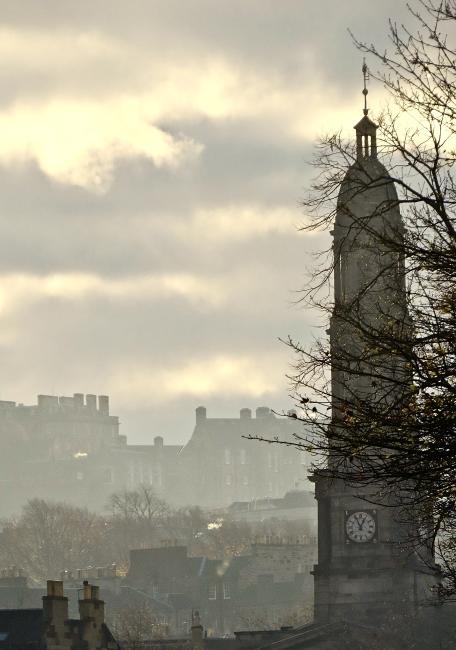 Turbulent sky and Edinburgh Castle behind the steeple of Broughton St Mary's.